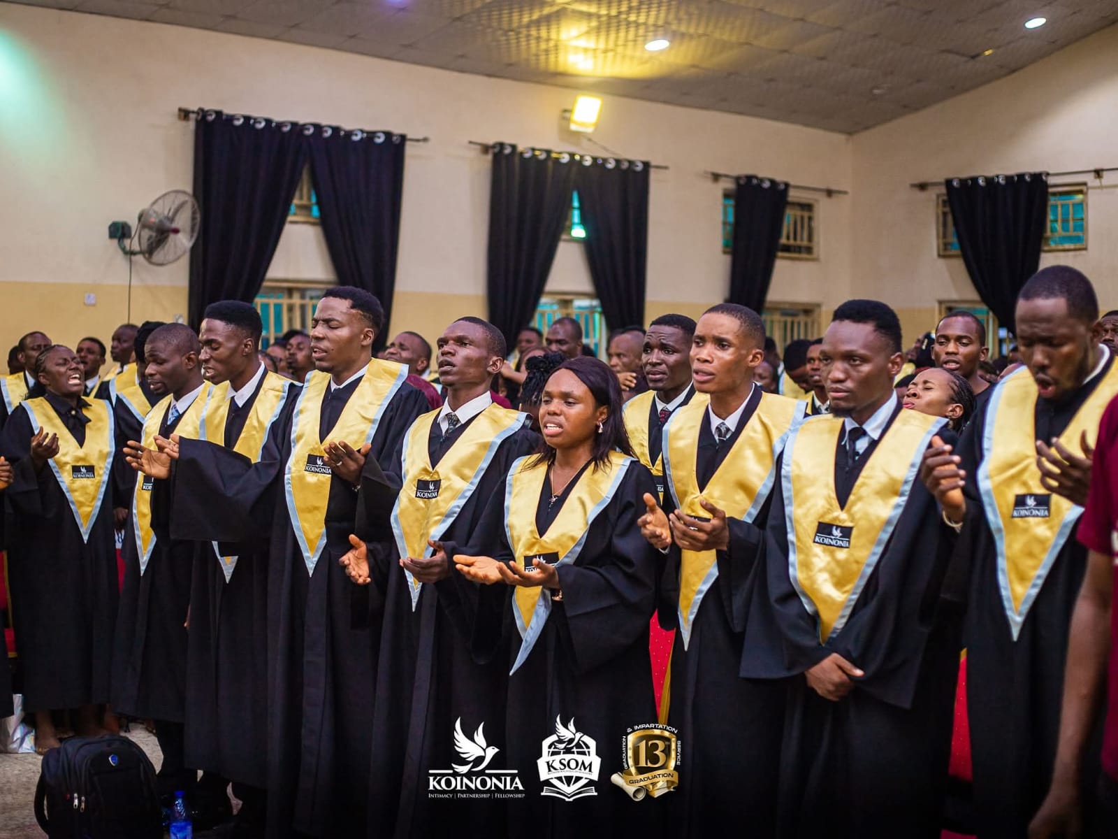 Graduating students stand and listens